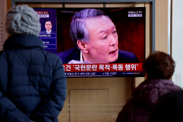 People watch a news report on the sentencing trial of South Korean former president Yoon Suk Yeol’s insurrection case in Seoul