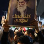 Supporters of Iraqi Shi’ite armed groups gather near the entrance of Baghdad’s Green Zone to show support for Iran, in Baghdad
