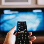 Closeup of the hand holding the remote control.