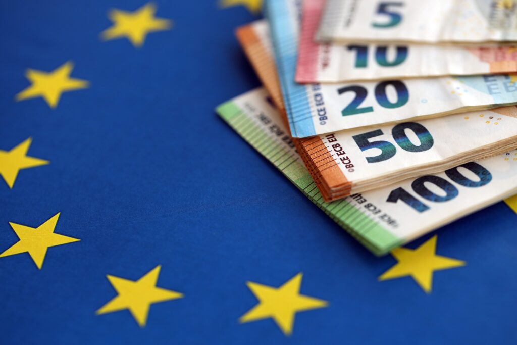 European eur currency money bills on Euro union blue flag close up