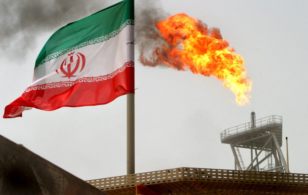 FILE PHOTO: A gas flare on an oil production platform in the Soroush oil fields is seen alongside an Iranian flag in the Gulf