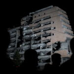 People stand in front of a destroyed military headquaters as Serbia marks the 16th anniversary of the NATO bombing campaign in Belgrade