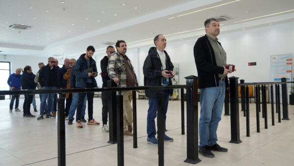 Foreign oil company personnel queue to cross into Kuwait at the Safwan border crossing, as companies evacuate staff following Iranian strikes in the region, in Basra