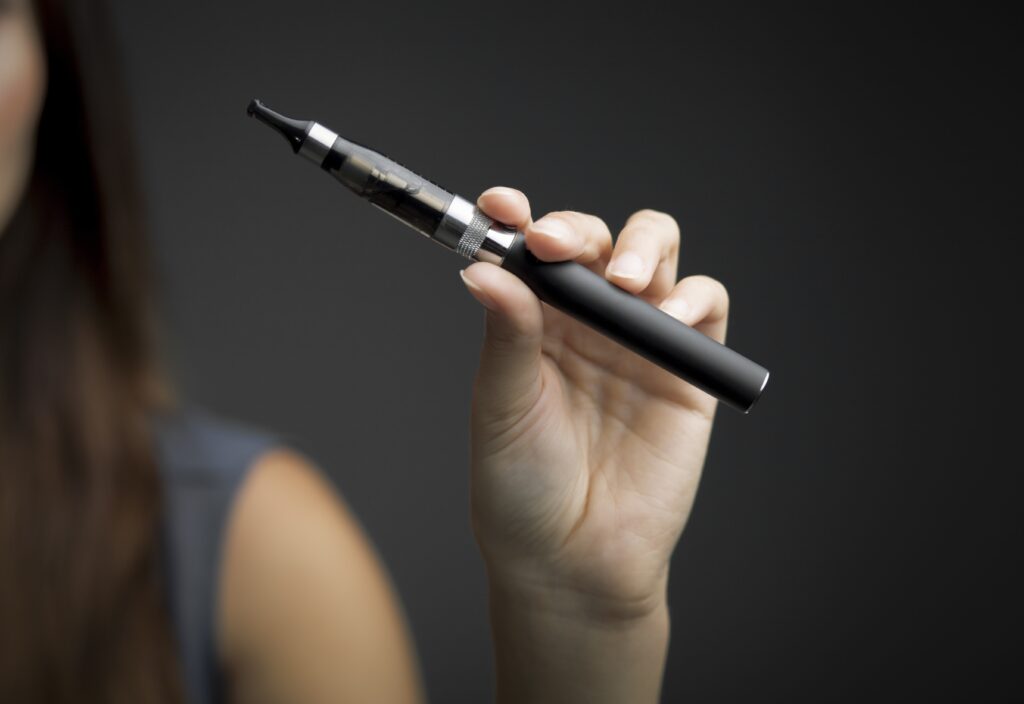 E-cigarette in woman’s hand close up