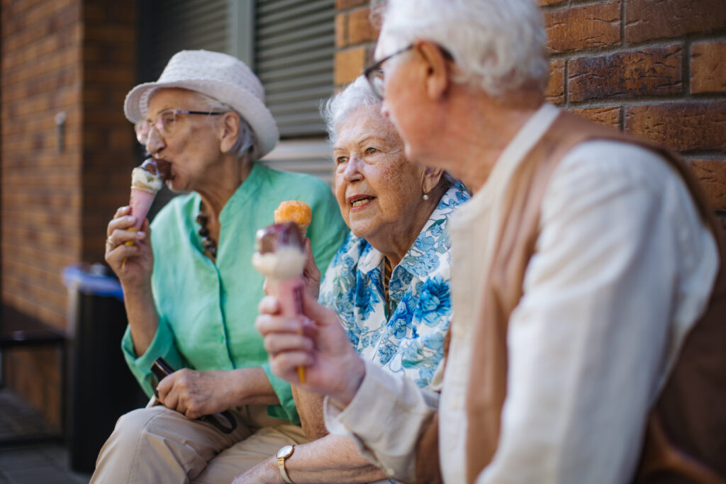 Portrait of three senior friends in the city, eating ice cream on a hot summer day.