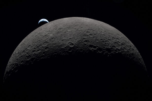 FILE PHOTO: A view of Earth, partially hidden by the Moon, photographed through the Orion spacecraft window