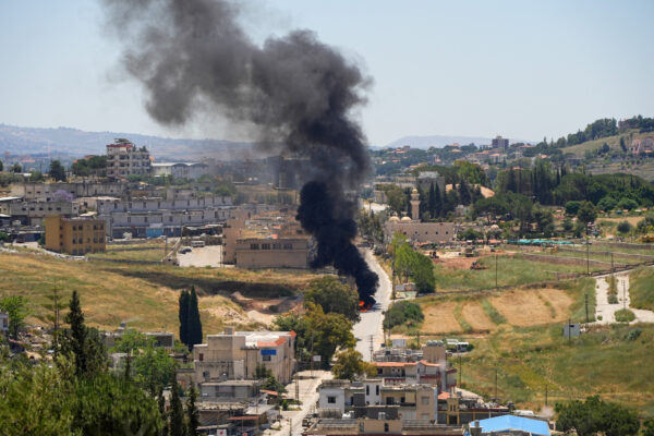 Black smoke billows at a strike scene following an Israeli strike on a car as seen from Nabatieh