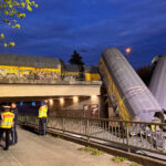 Two cars of a freight train derailed after a collision and fell off a bridge in Munich