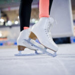 Figure skater woman at ice skating rink.
