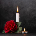 front-view-of-burning-candle-with-red-flower-on-gr-2026-03-18-11-01-39-utc