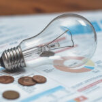 Electricity bills with light bulb and coins