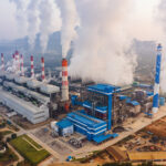 Aerial view of Mae Moh Coal Power Plant with smoke and toxic air from chimney. Factory industry. Electricity tower in energy or pollution environment concept. Lampang City, Thailand
