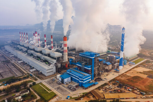 Aerial view of Mae Moh Coal Power Plant with smoke and toxic air from chimney. Factory industry. Electricity tower in energy or pollution environment concept. Lampang City, Thailand