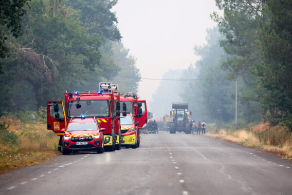 Firefighters gather amid smoke from a wildfire near Lacanau