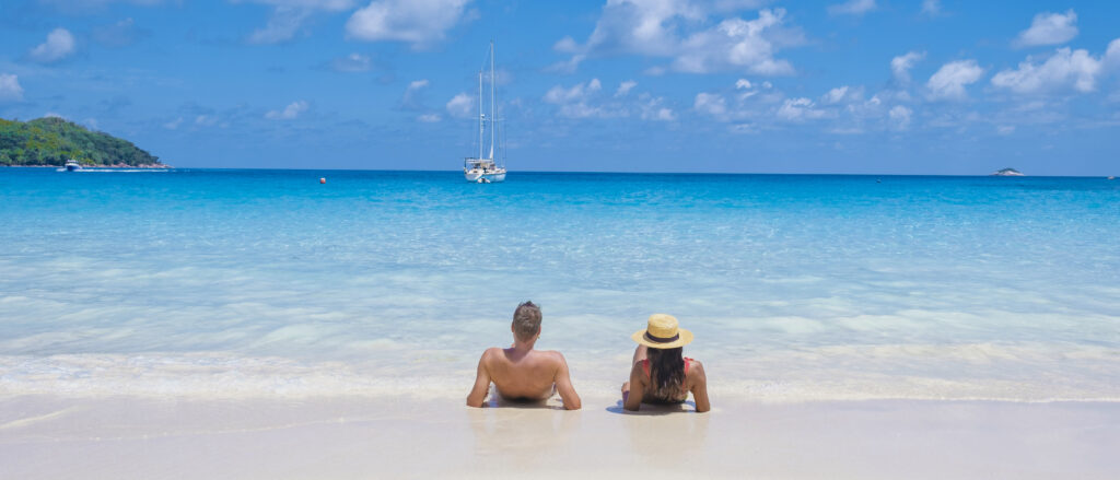 Anse Lazio Praslin Seychelles, young couple men and woman on a tropical beach during a luxury vacation in the Seychelles. Tropical beach Anse Lazio Praslin Seychelles