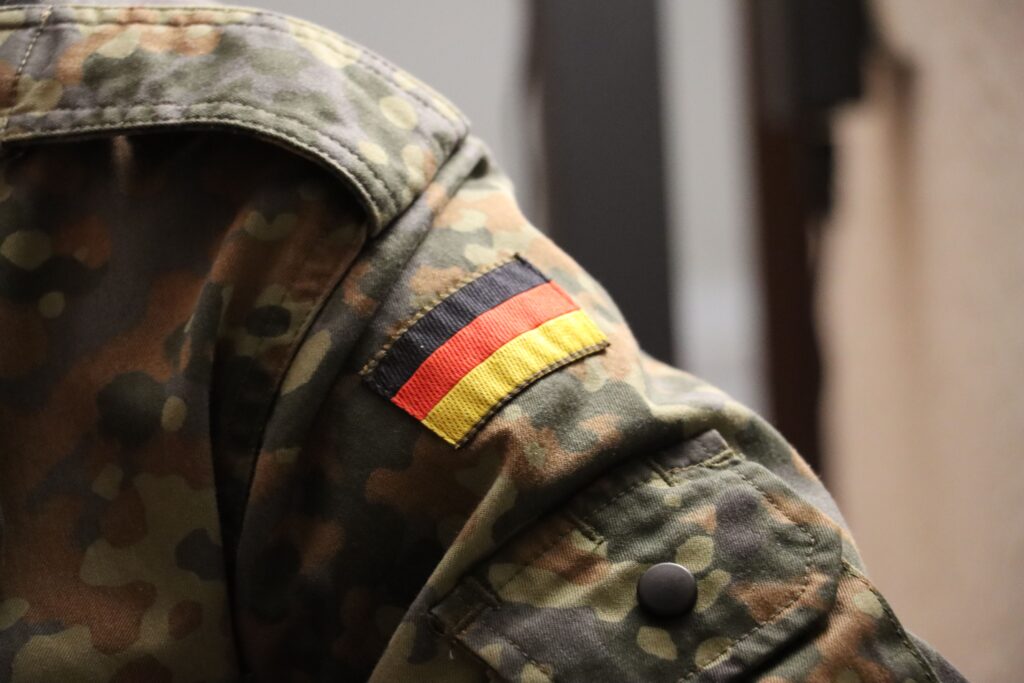 Green and brown camouflage jacket with a flag of Germany patch