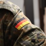 Green and brown camouflage jacket with a flag of Germany patch