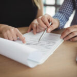 Mid section executives discussing over paper at desk in office