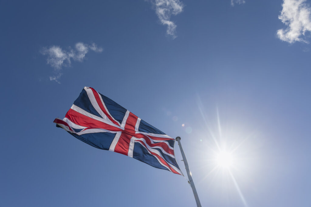 Union Jack in blue sky with backlight