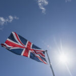 Union Jack in blue sky with backlight
