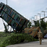 FILE PHOTO: Ukrainian service members walk next to a launcher of a Patriot air defence system an undisclosed location in Ukraine
