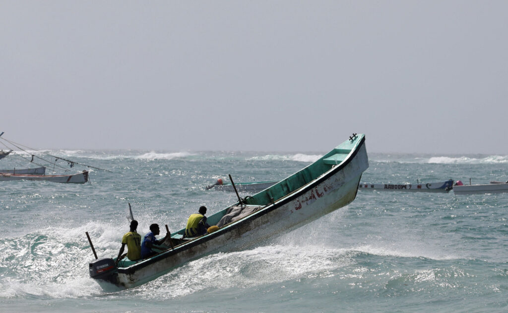 Somali fishermen sail over a wave in the Indian Ocean waters near Liido beach in Mogadishu