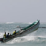 Somali fishermen sail over a wave in the Indian Ocean waters near Liido beach in Mogadishu