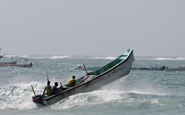 Somali fishermen sail over a wave in the Indian Ocean waters near Liido beach in Mogadishu