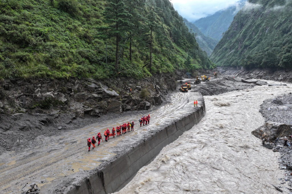 Firefighters conduct search and rescue operations after a mudslide in Gyirong county