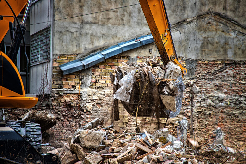 Excavator breaks old house. Freeing up space for the constructio