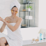 Lady applies eye patches and moisturizing skin with lotion. Relaxation at spa resort.