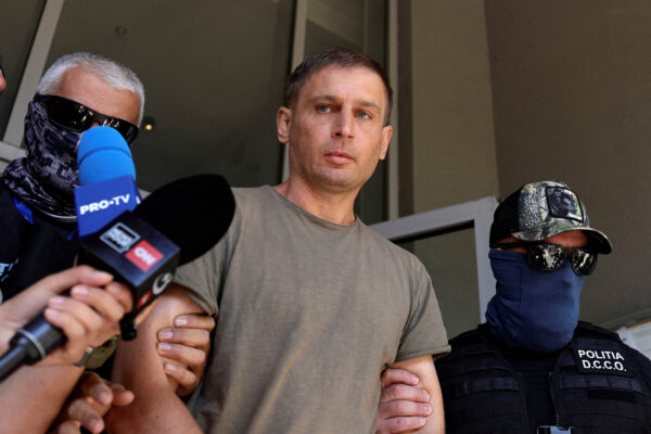 A Russian citizen believed to be involved in a thwarted sabotage operation coordinated by Russia on Romanian territory is escorted outside the DIICOT headquarters, in Bucharest