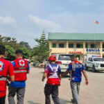 Emergency personnel walk at a site of a deadly shooting at a school in Banga