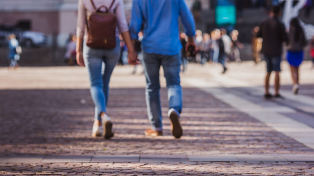 Tourist couple walking on cobblestone street vacation in europe on holiday break