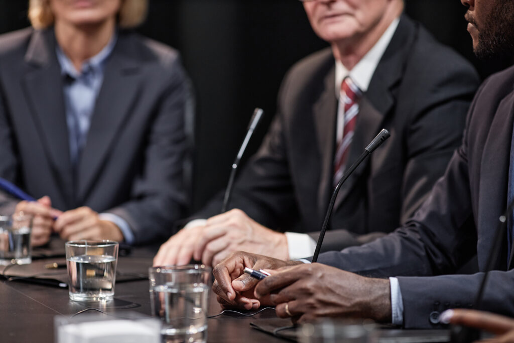 Hands of Black Man Sitting at Table while Speaking at Political Meeting
